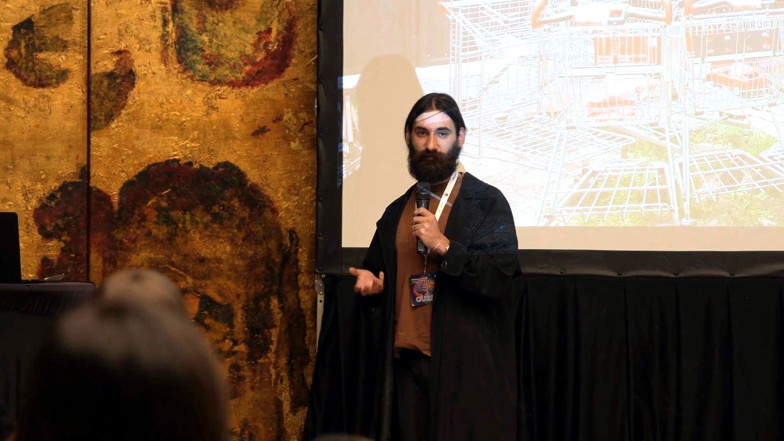 A speaker in front of a projected city drawing